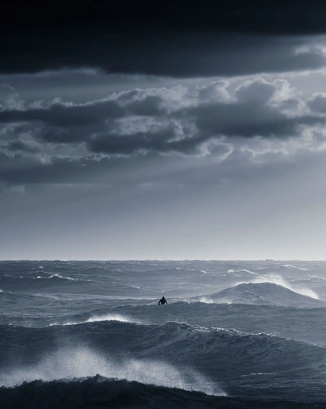 A lone figure in the vast open ocean